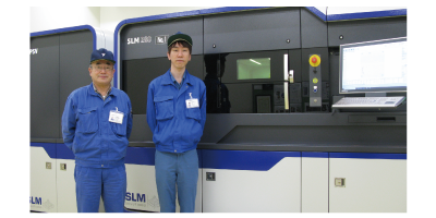 In front of the metal 3D printer: IHT Development Dept.,Mr. Fumikazu Goto & Mr. Masaomi Kawabe